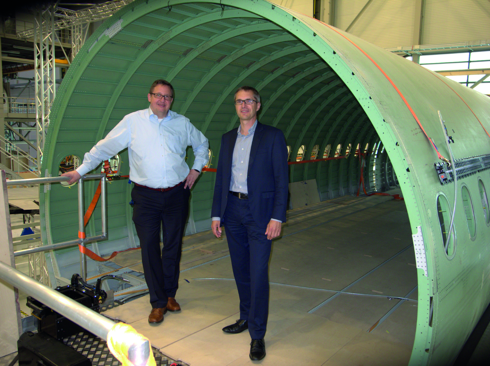 Das Bild zeigt Eckard Gatzmanga (links), Leiter CAD/DMU Backbone/ICT Develop bei Airbus, und Kilian Grefen (rechts), Geschäftsführer der Ascon Systems GmbH, im Zentrum für Angewandte Luftfahrtforschung, wo eine digitale Pilotfabrik entstehen soll.