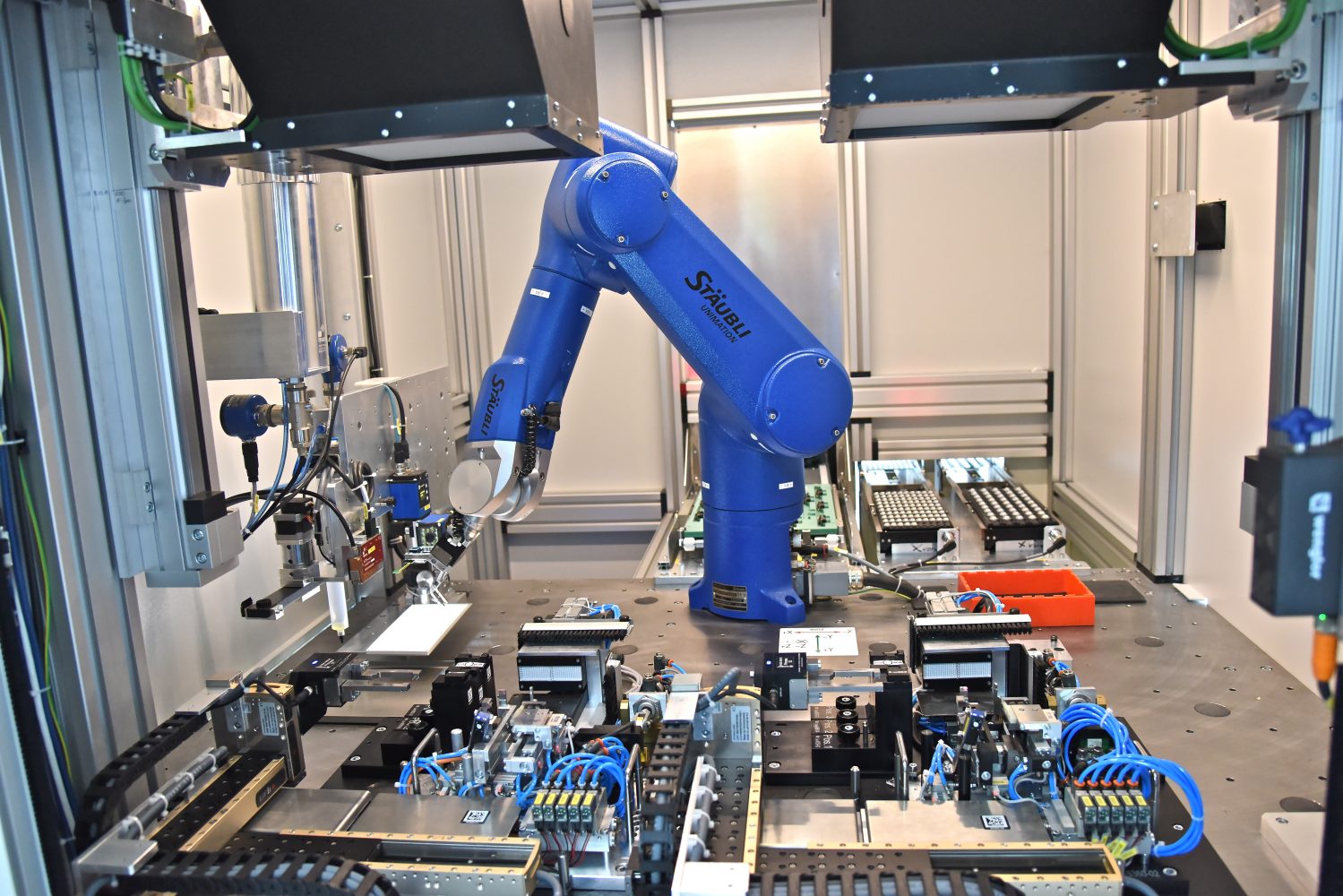 Die Roboterzelle verfügt über zwei identische Justagestationen für die hochgenaue Ausrichtung der Linsen. (Bild: Stäubli Tec-Systems GmbH)